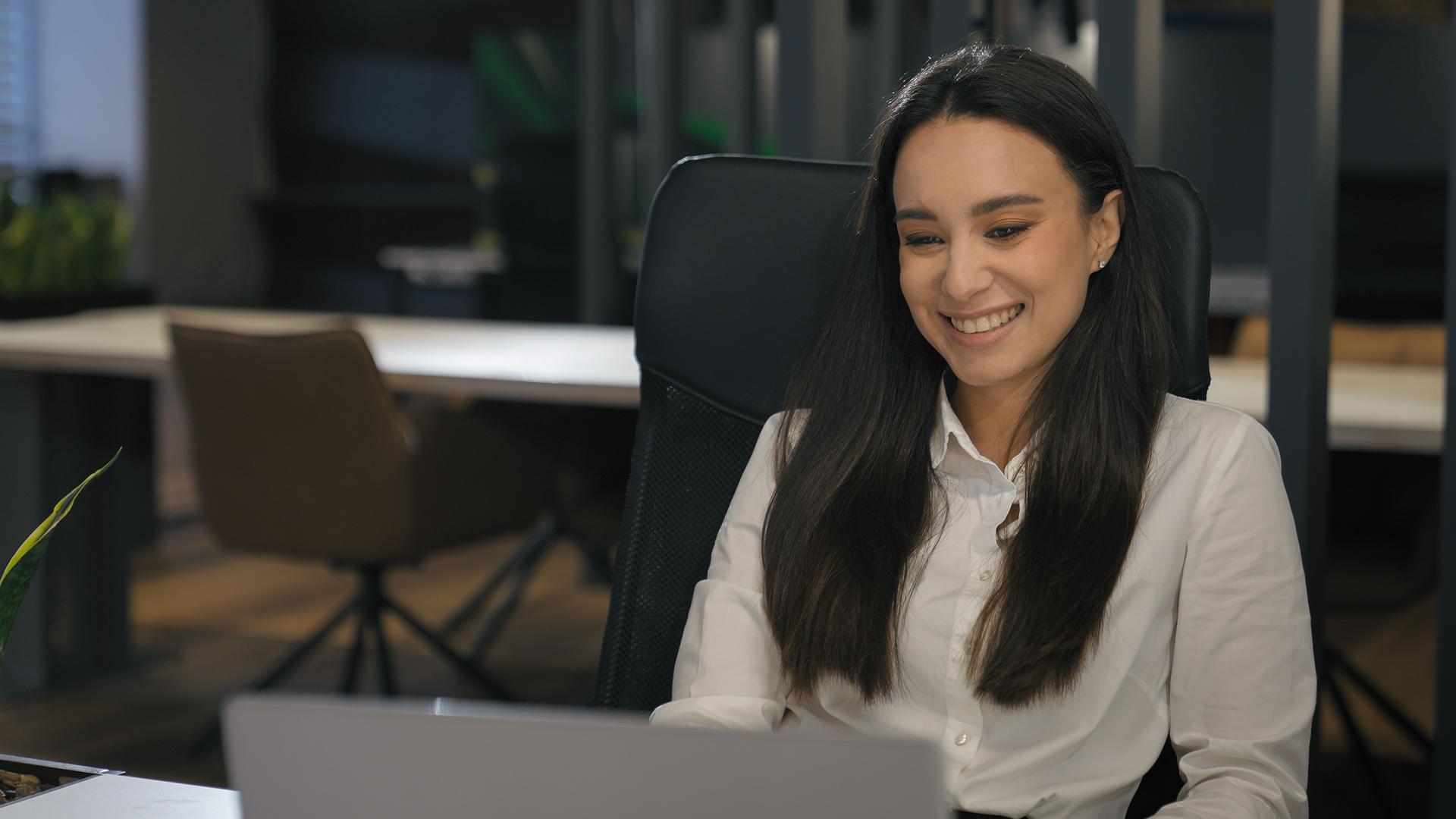 Inspired motivated Caucasian smiling business woman working at office table with laptop workplace smile happy satisfied businesswoman work online with computer task thinking achieve job good result